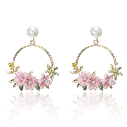 Eleganta örhängen i guld med blommor och pärlor